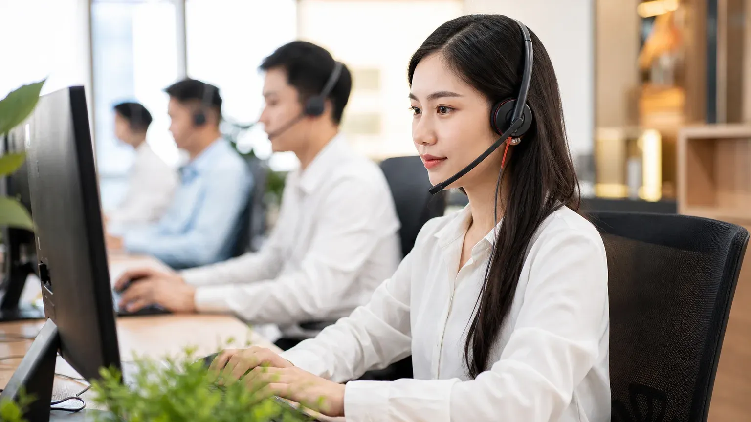 Nhân viên tổng đài AI đeo tai nghe chăm sóc khách hàng tại bàn làm việc